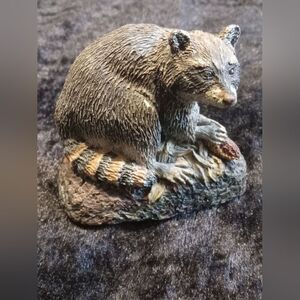 This is a rare and exquisite hand-painted menagerie of a raccoon in a natural po